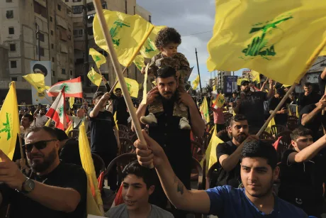 Oameni cu steaguri Hezbollah participând la o demonstrație în Liban.