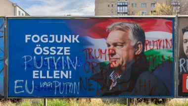 Viktor Orban pe un panou publicitar, cu mesaje politice scrise pe el.