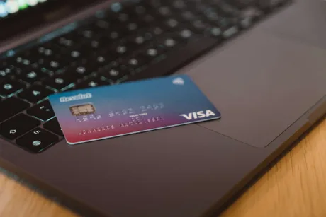 Card Revolut plasat pe un laptop, simbolizând plățile digitale în România.