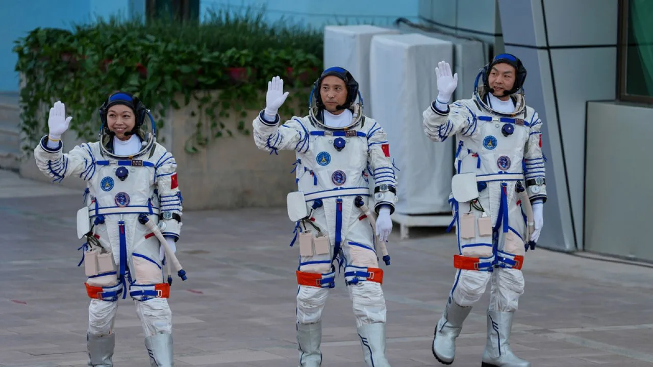 Trei astronauți salută înainte de lansarea misiunii Shenzhou-23 către stația Tiangong.
