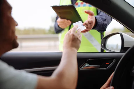 Un șofer primește o amendă de la un polițist rutier.