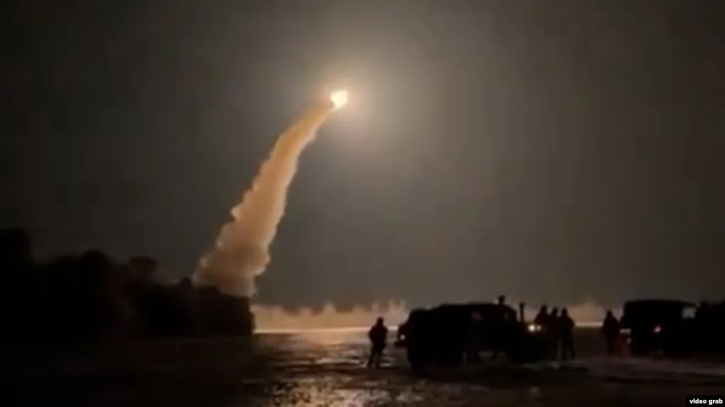 Lansare de rachetă în noapte, cu fum și lumină intensă.