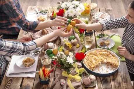 Masa festivă cu preparate delicioase și decor floral vibrant.