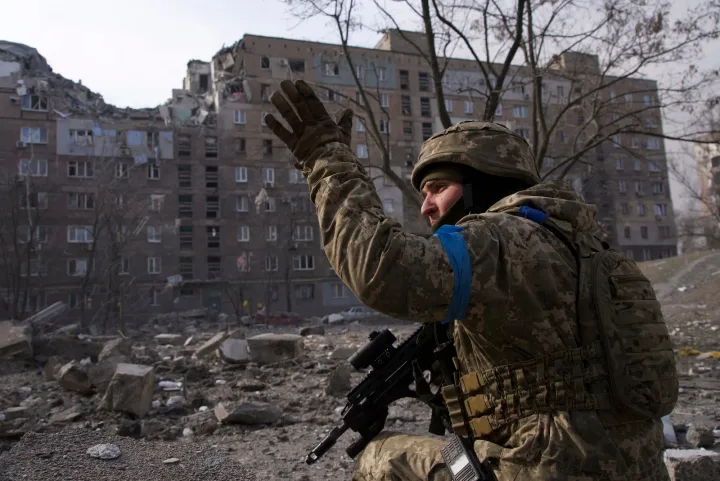 Soldat ucrainean în fața clădirilor distruse, semn al conflictului.