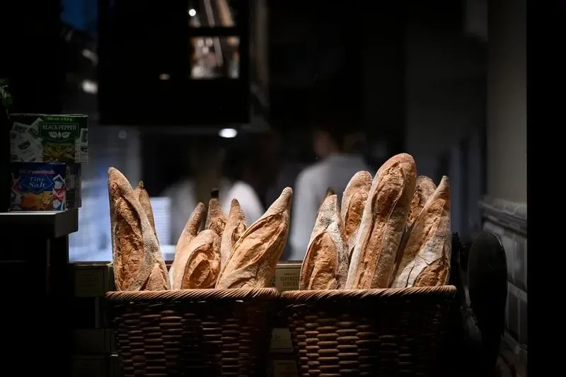 Baghete proaspete expuse într-un coș, simbol al tradiției franceze.