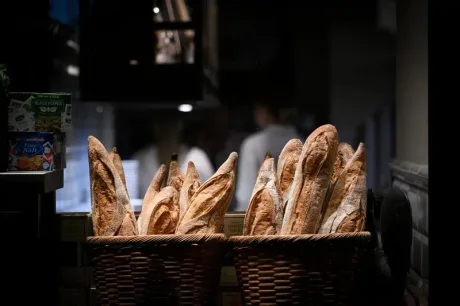 Baghete proaspete expuse într-un coș, simbol al tradiției franceze.