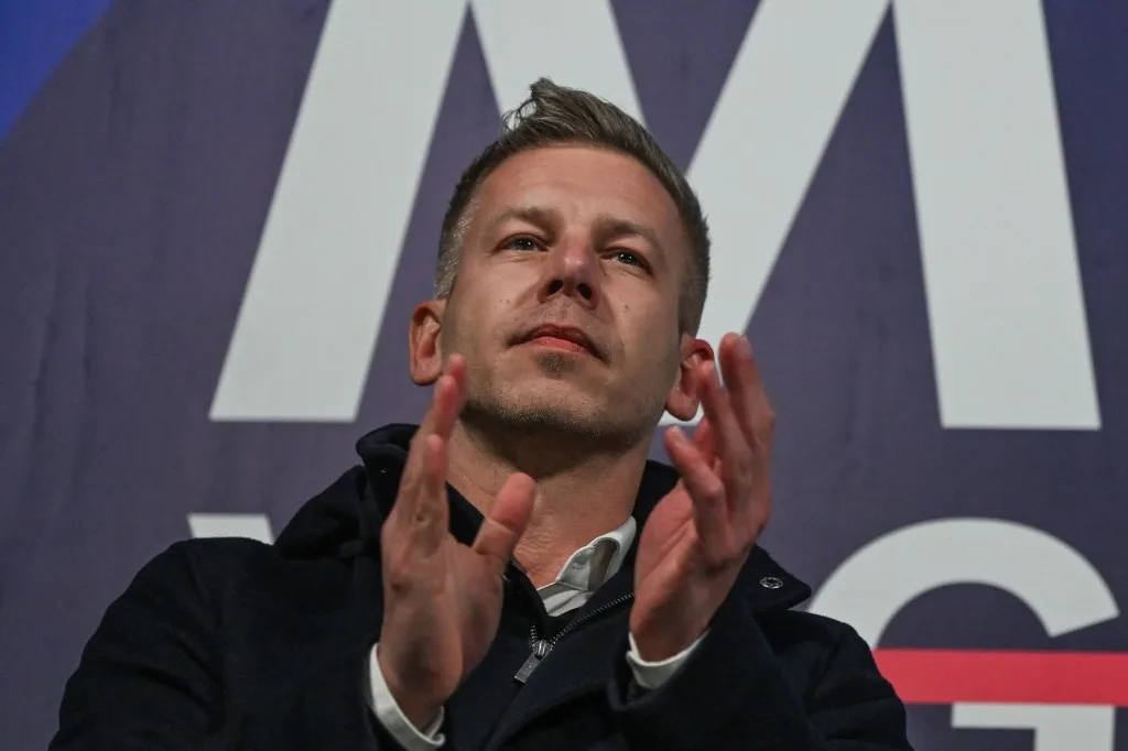 Lider politic aplaudând la un eveniment electoral important.