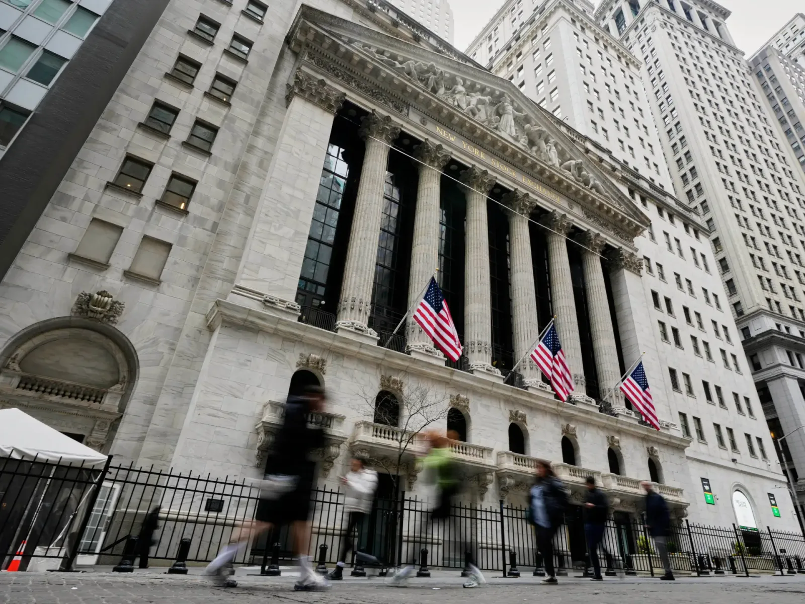 Clădirea Bursei de Valori din New York, cu steaguri americane la intrare.