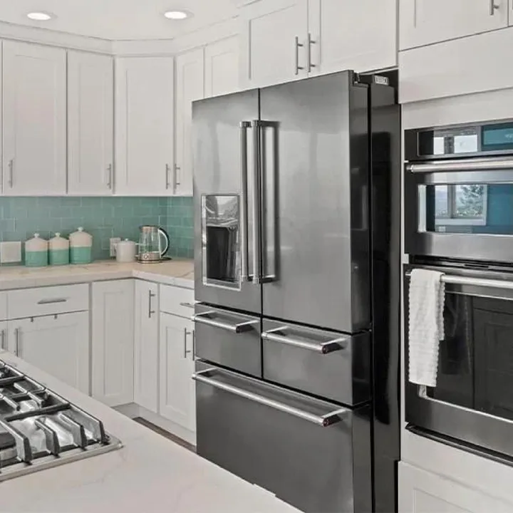 Frigider modern în bucătărie, cu design elegant și finisaj negru.