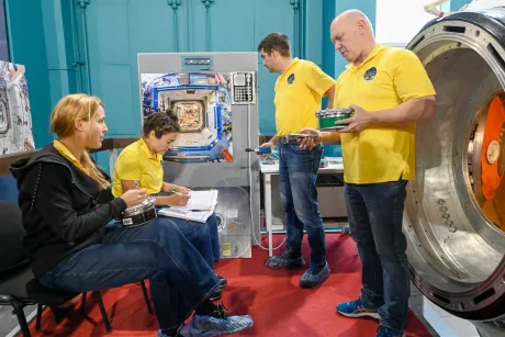 Cercetători discutând despre tehnologia capsulei Orion în laborator.