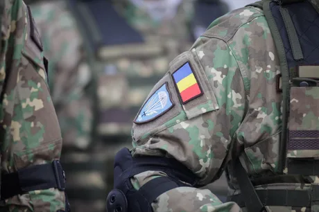 Uniformă militară cu insigne și detalii camuflate, simbolizând forțele armate române.