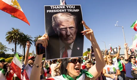 Protest împotriva regimului iranian, cu pancarte și steaguri naționale.