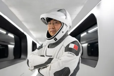 Chun Wang îmbrăcat în costum de astronaut, pregătit pentru misiune interplanetară.