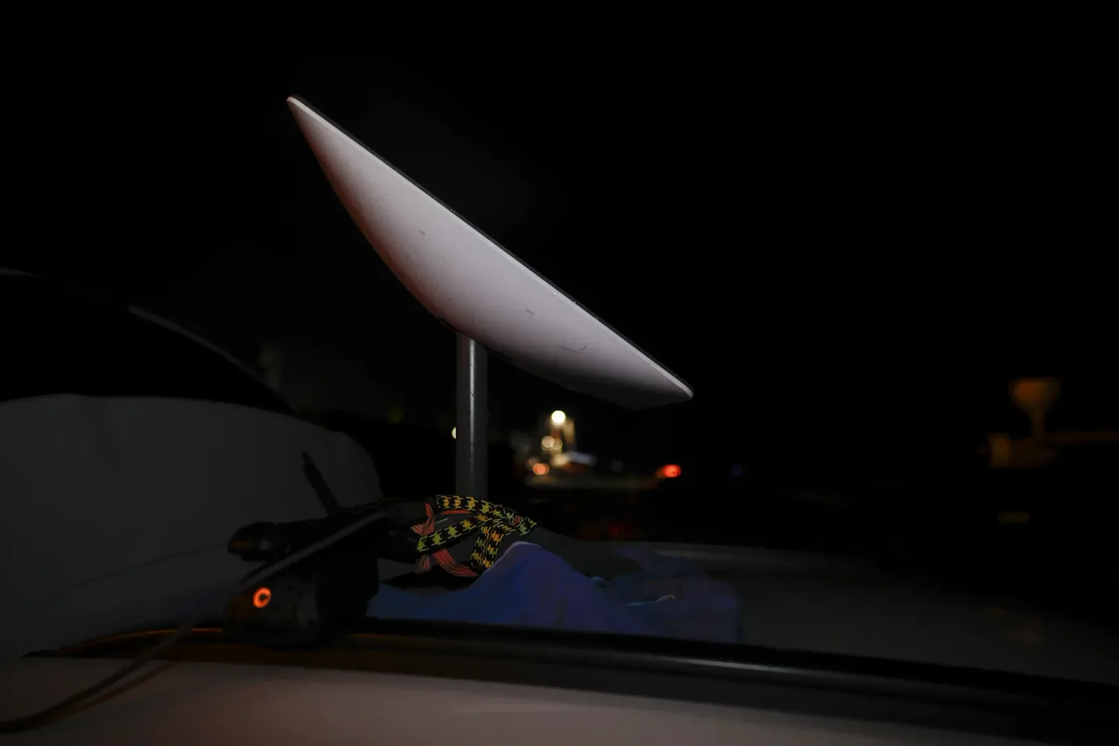 Antena de internet montată pe un vehicul, în noapte, simbolizând conectivitatea.