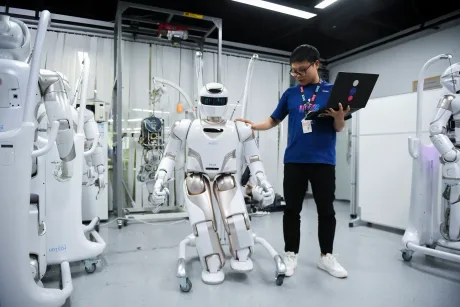 Un robot interacționează cu un om într-un mediu tehnologic avansat.
