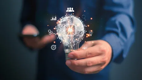 Un bărbat ține o lampă cu simboluri de inteligență artificială.