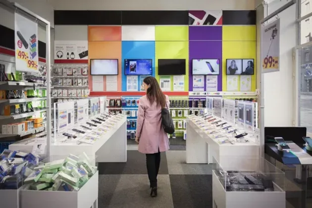 Un magazin de telefoane mobile cu diverse modele expuse pe rafturi.