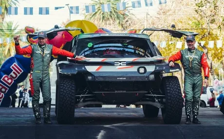 Echipa Dacia Sandriders sărbătorește succesul în raliu, cu mașina pregătită pentru următoarele etape.