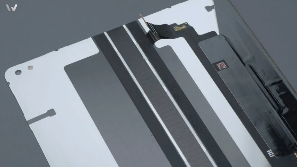 Mâini care țin o parte din balama OPPO Find N6, detaliu de asamblare.