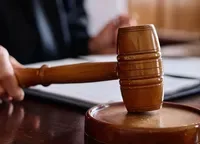 Ciocan de judecător pe birou, simbolizând justiția și deciziile legale.