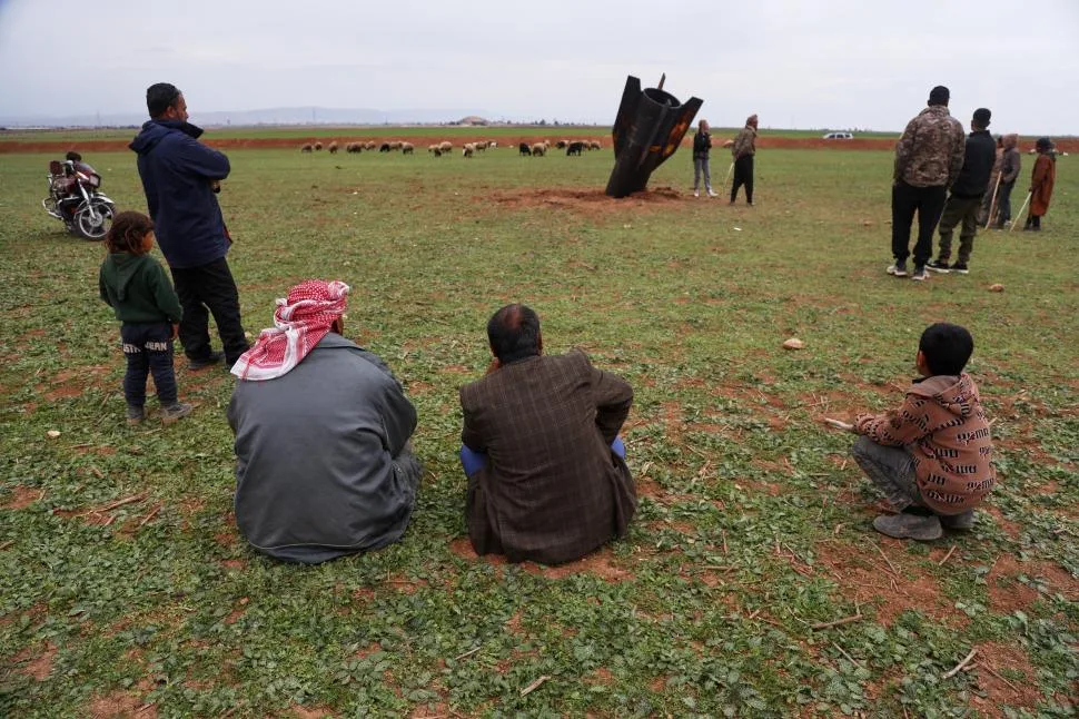 Localnici observă racheta în timp ce oile pasc în apropiere.