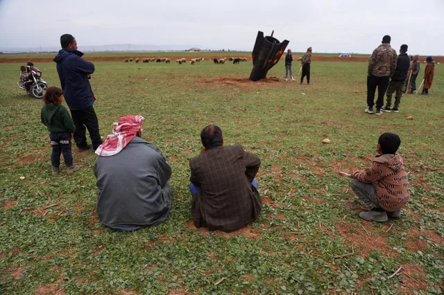 Localnici observă racheta în timp ce oile pasc în apropiere.