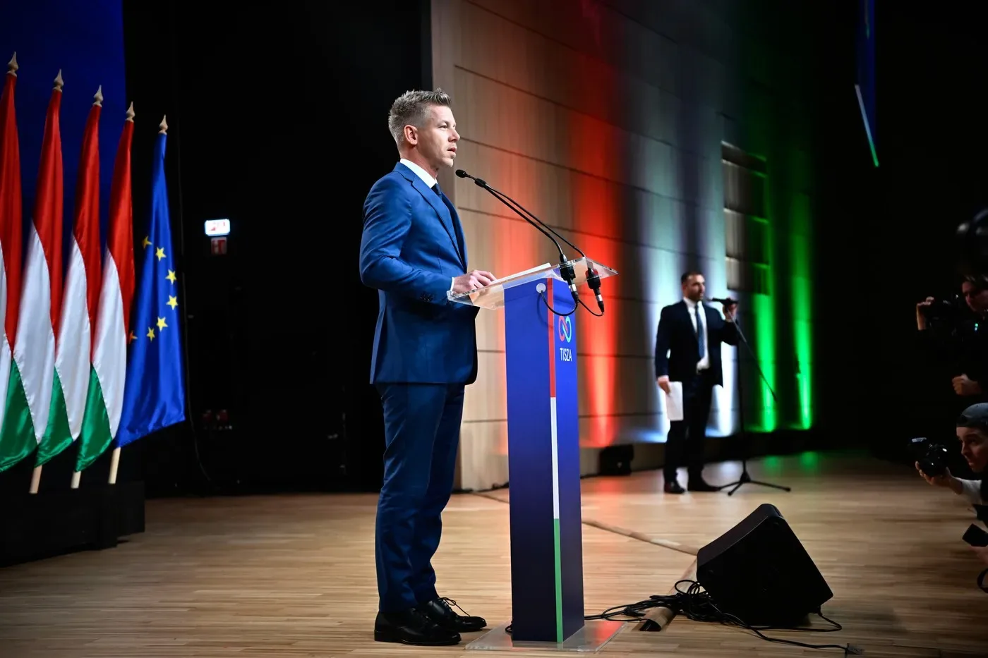 Peter Magyar susține un discurs în fața unei audiențe, cu steaguri ungare în fundal.