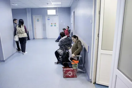 Pacienți așteptând în sala de așteptare a unui spital, atmosfera calmă și organizată.