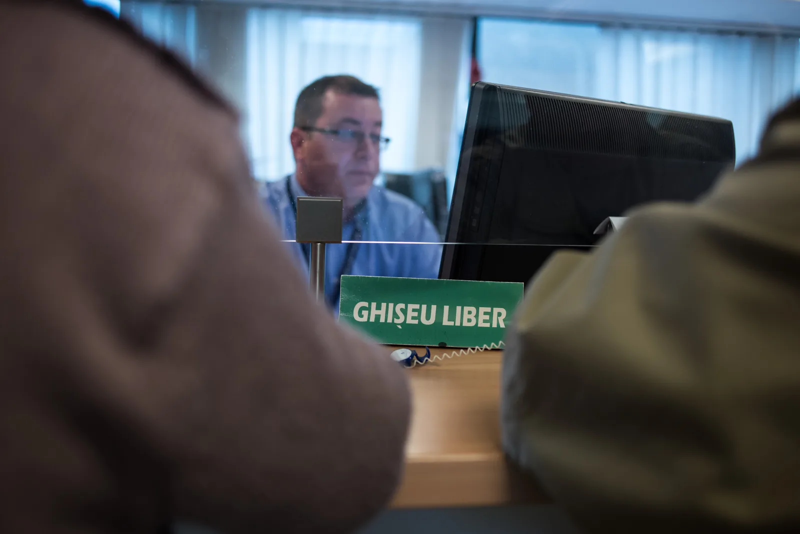 Persoane discutând despre impozitul pe venit la ghișeu.