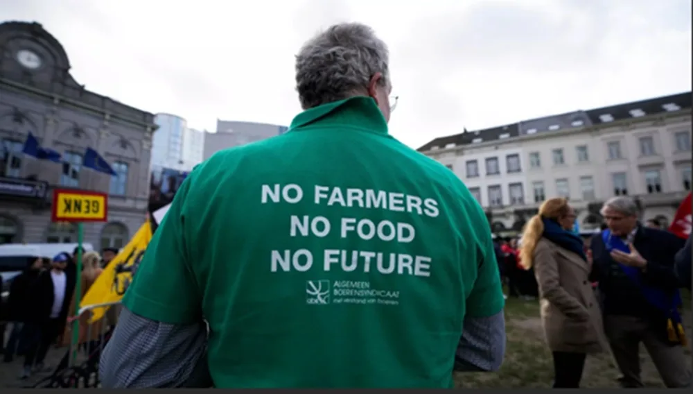 Fermier protestând la Bruxelles pentru reducerea costurilor îngrășămintelor.