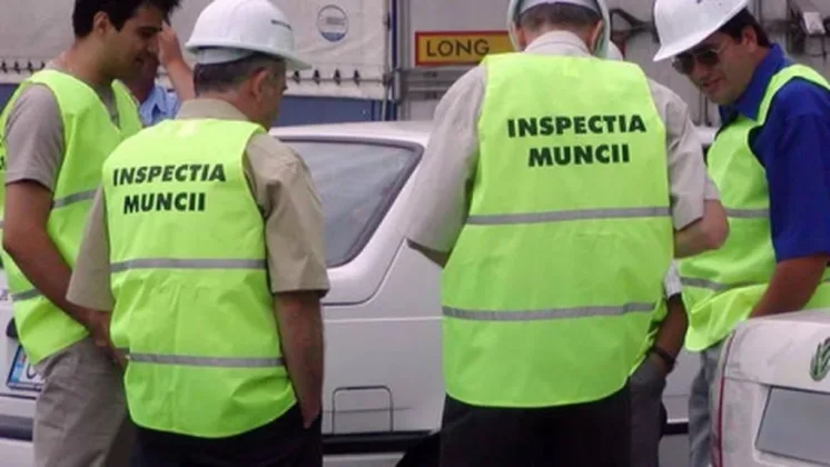 Inspectori de muncă verificând respectarea normelor de securitate.