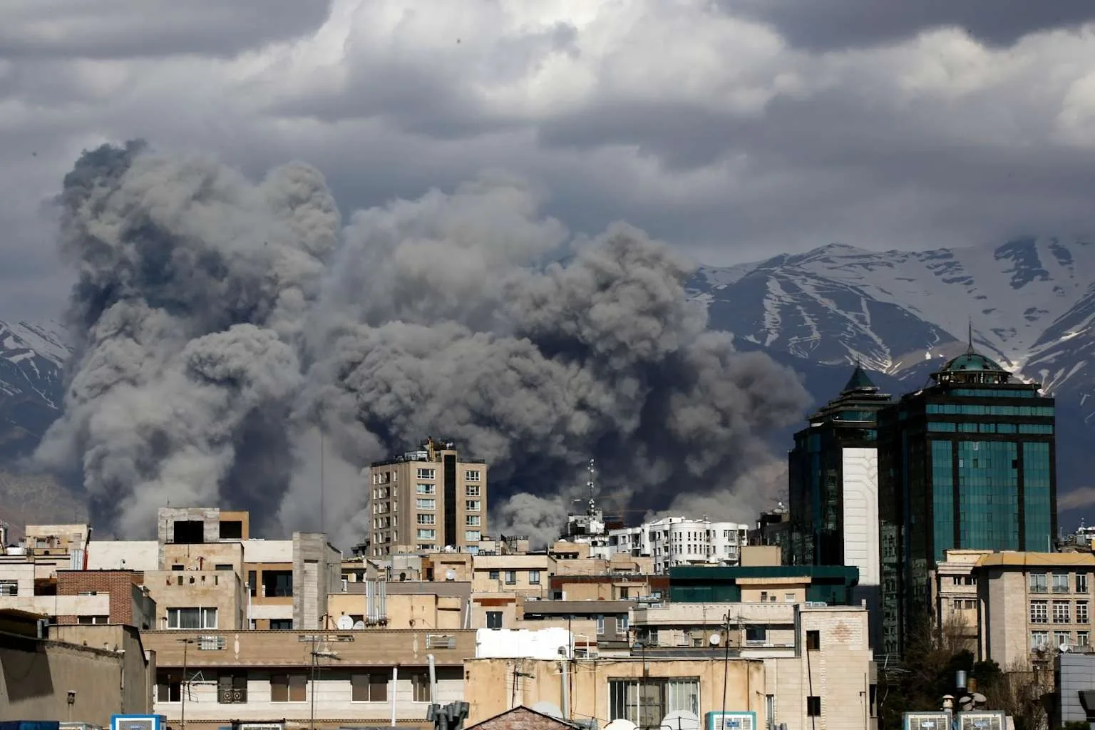 Fum gros se ridică deasupra clădirilor din Teheran după atacuri aeriene.