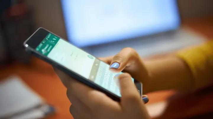 Utilizator interacționând cu aplicația WhatsApp pe telefonul mobil.