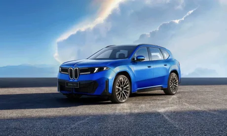 Mașină electrică BMW iX3 expusă pe fundal de cer senin.