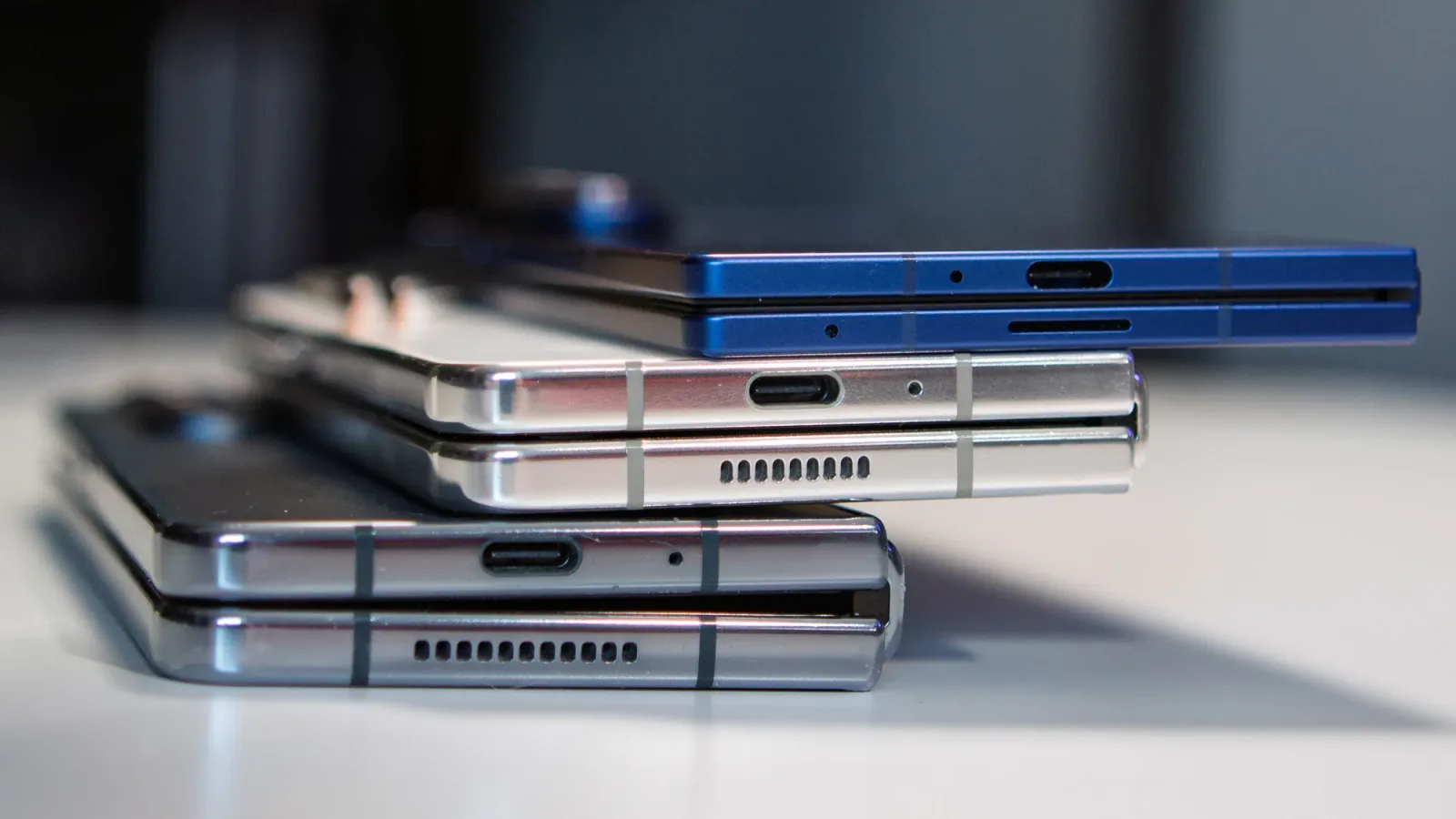 Trei telefoane pliabile Samsung așezate unul peste altul, evidențiind designul modern.