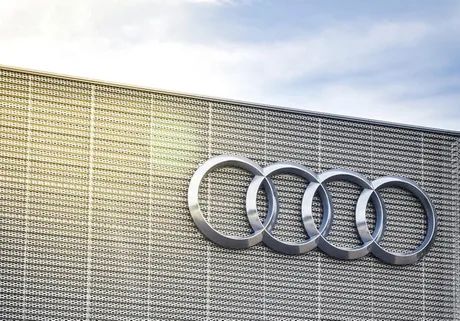 Logo-ul Audi pe un perete modern, simbolizând inovația în industria auto.