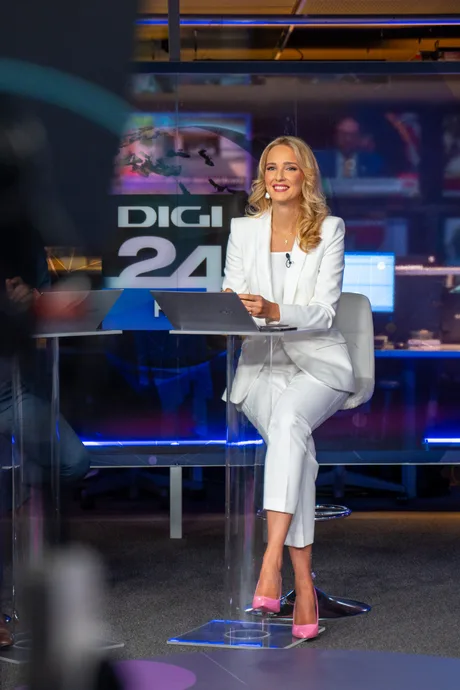 Teodora Tompea, jurnalistă, la birou, zâmbind în fața camerei.