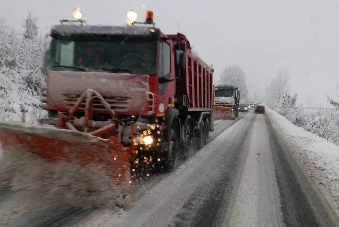 Utilaje de deszăpezire pe drum acoperit de zăpadă.