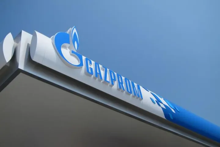 Logo-ul Gazprom pe un fundal albastru, simbolizând compania energetică.