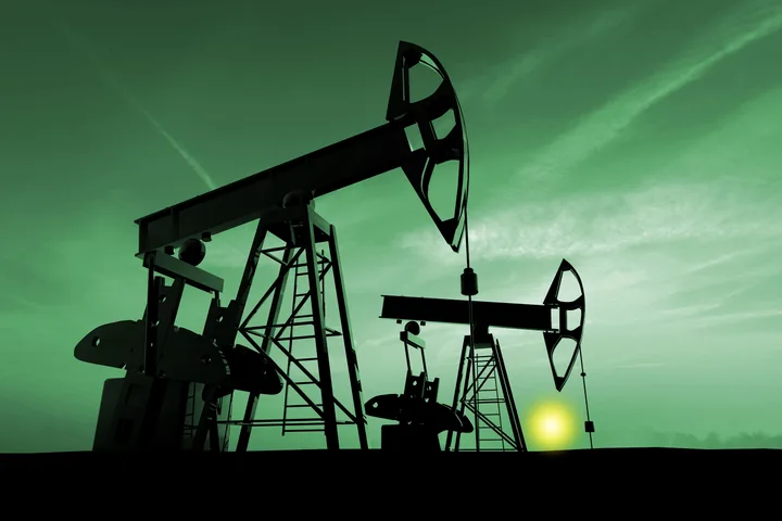 Pompe de extracție a petrolului în lumina dimineții, simbol al crizei energetice.