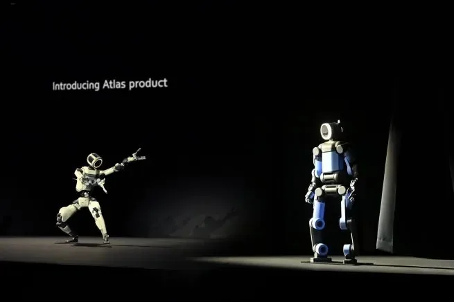 Roboți umanoizi Atlas pe scenă, pregătiți pentru producție în fabrici.