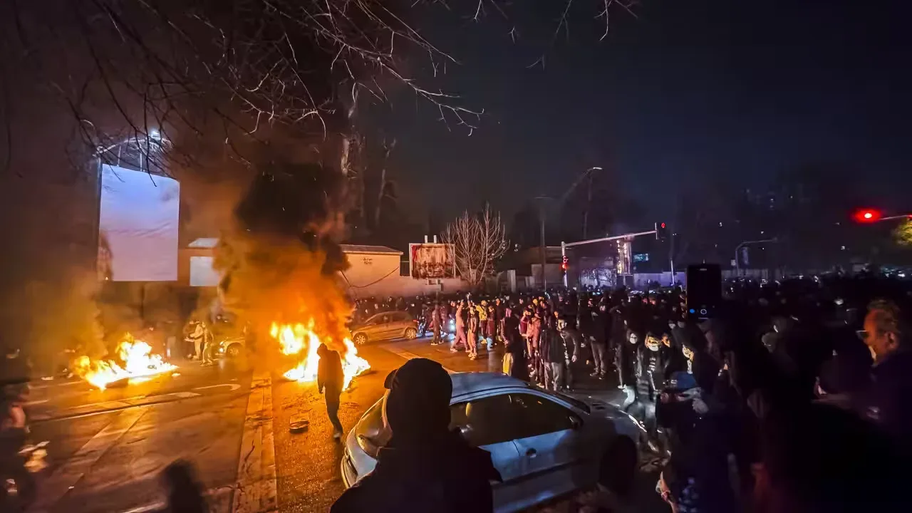 Protestatari în fața unei flăcări, în timpul unrestului din Teheran.