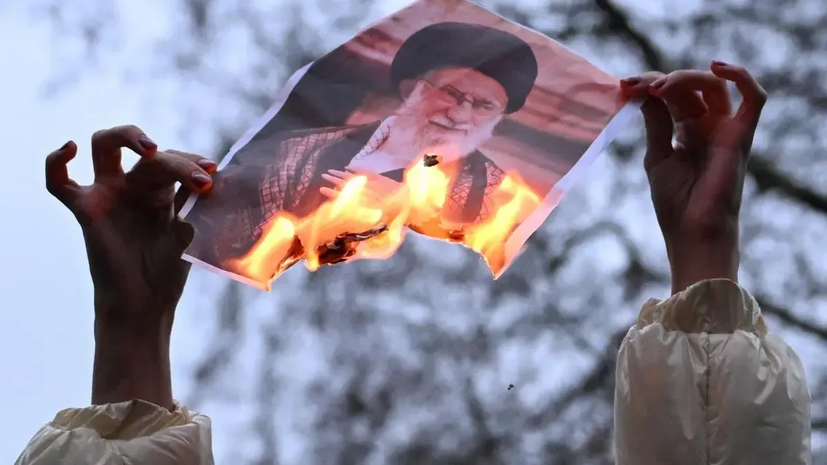 Imagine simbolică cu o fotografie arsă a liderului iranian.