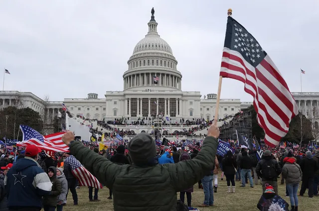 Protest la Capitoliu cu steaguri americane în fundal.