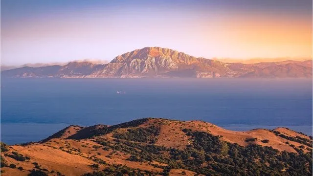 Peisaj montan cu vedere spre mare și insula din depărtare