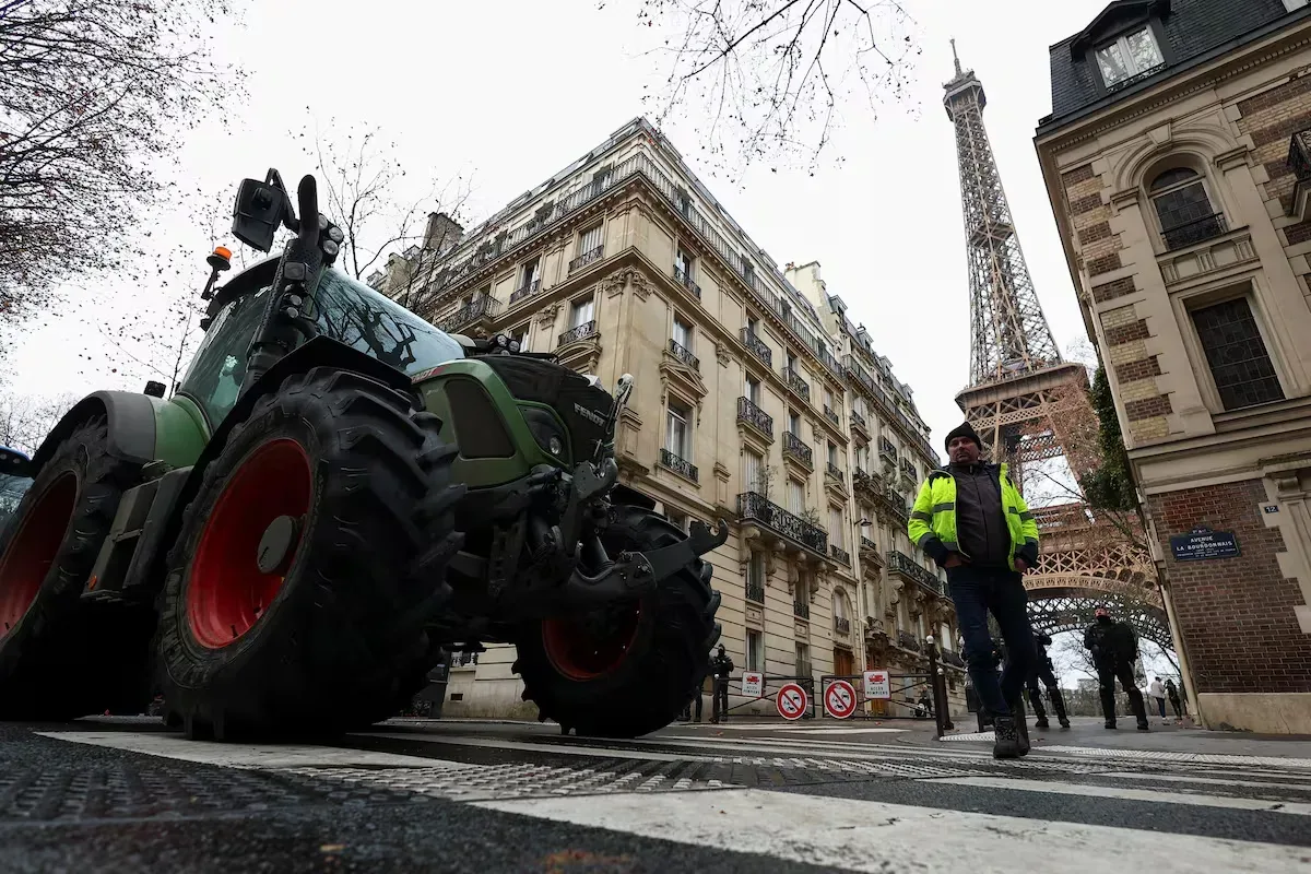 Tractor pe străzile Parisului, cu Turnul Eiffel în fundal.