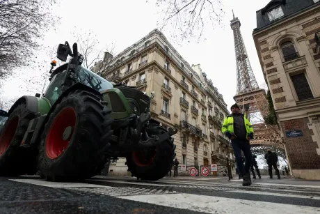Tractor pe străzile Parisului, cu Turnul Eiffel în fundal.