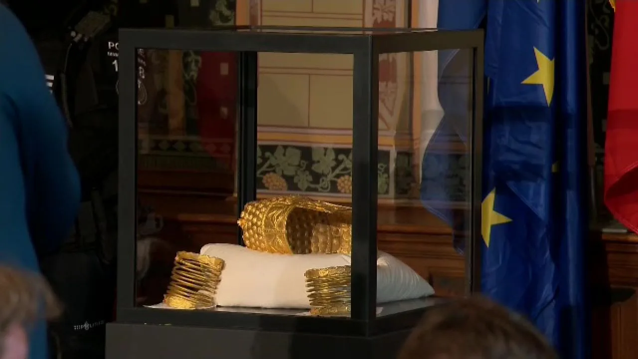 Tezaurul românesc expus într-un cazan de sticlă, evidențiind aurul recuperat.