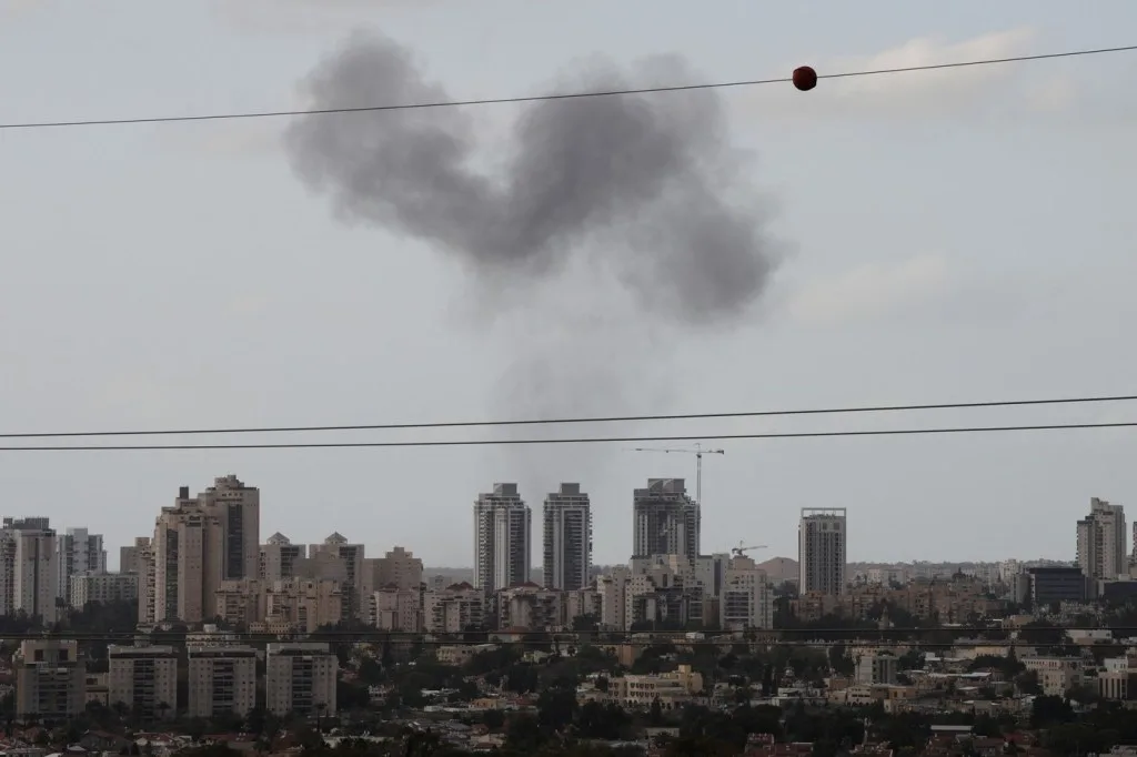Fum de la un incident în oraș, clădiri în fundal.