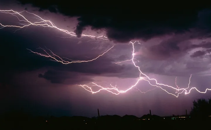 Furtuni electrice cu fulgere pe un fundal întunecat, simbolizând fenomene meteo extreme.